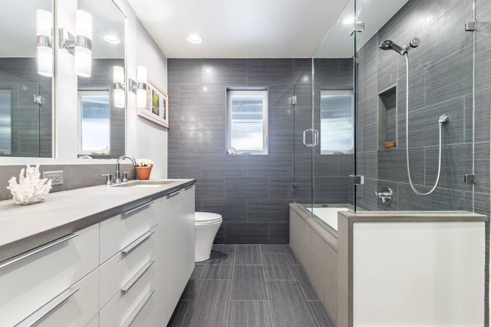 Small modern master bathroom in Dallas with flat-panel cabinets, white cabinets, an undermount tub, a shower/bathtub combo, a two-piece toilet, black tile, porcelain tile, white walls, porcelain floors, an undermount sink and granite benchtops.