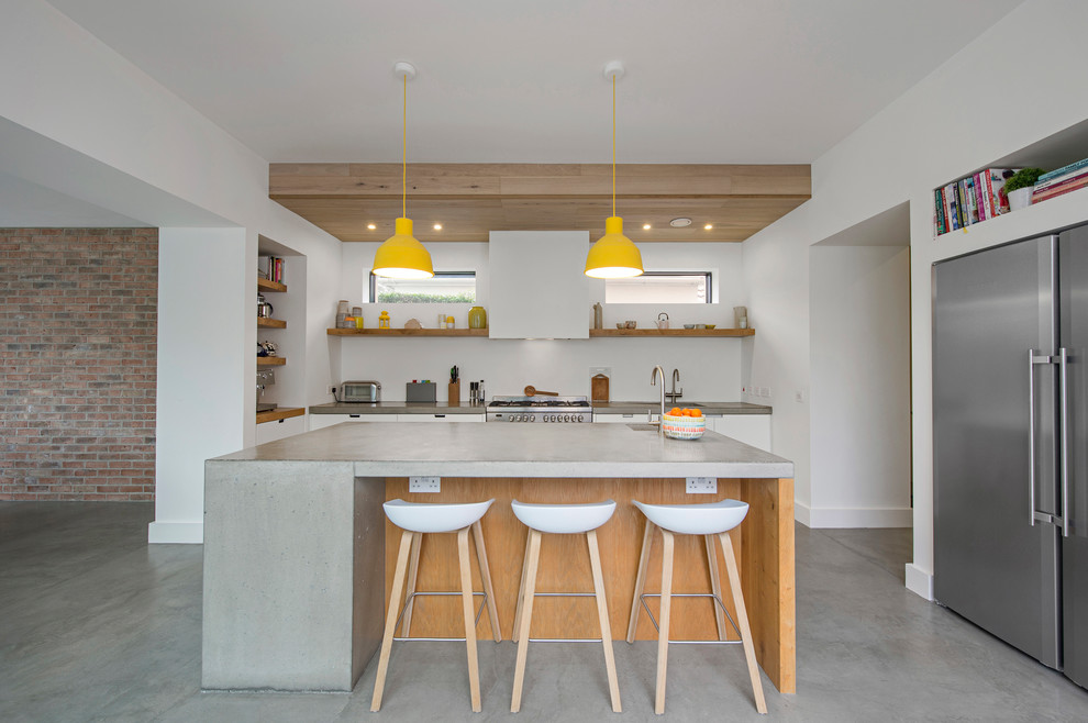 Mid-sized contemporary single-wall kitchen in Dublin with concrete benchtops, stainless steel appliances, concrete floors, with island and grey floor.