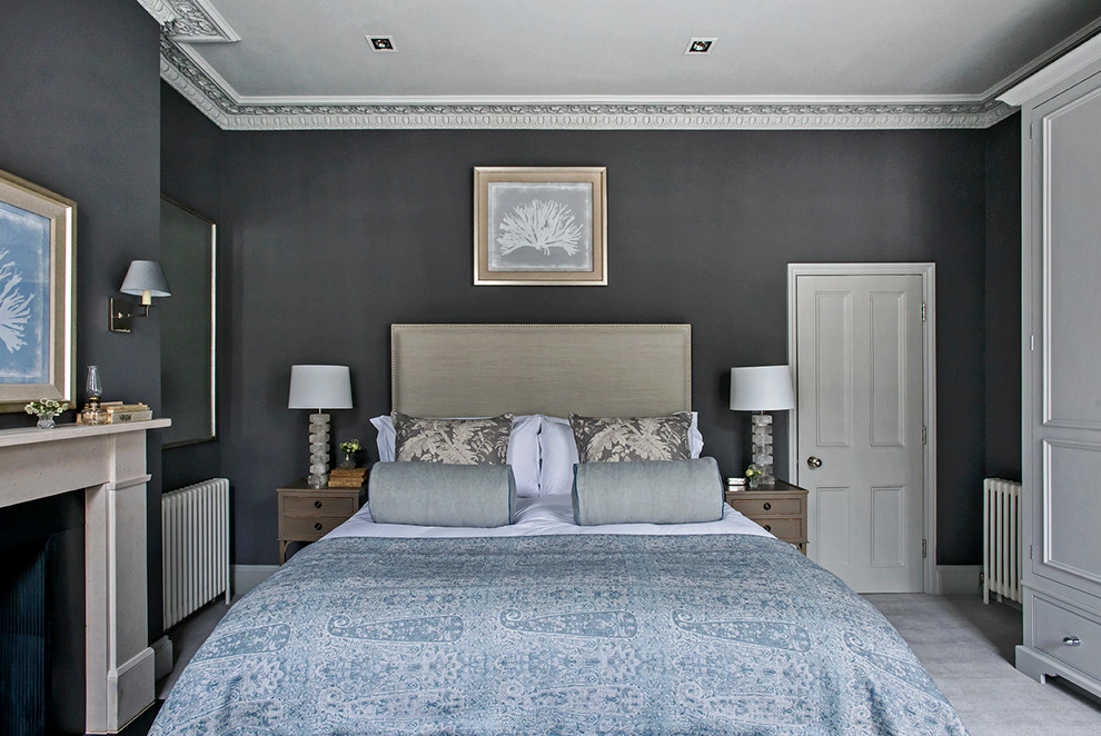 Photo of a transitional bedroom with black walls, carpet, a standard fireplace and grey floor.