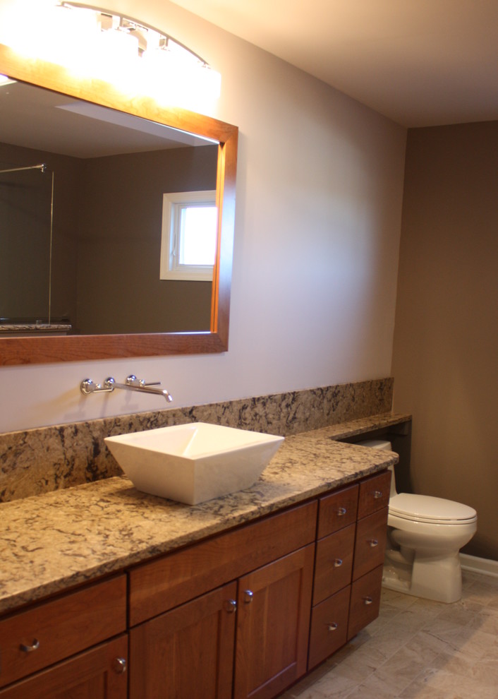 This is an example of a traditional bathroom in New York with a vessel sink and raised-panel cabinets.