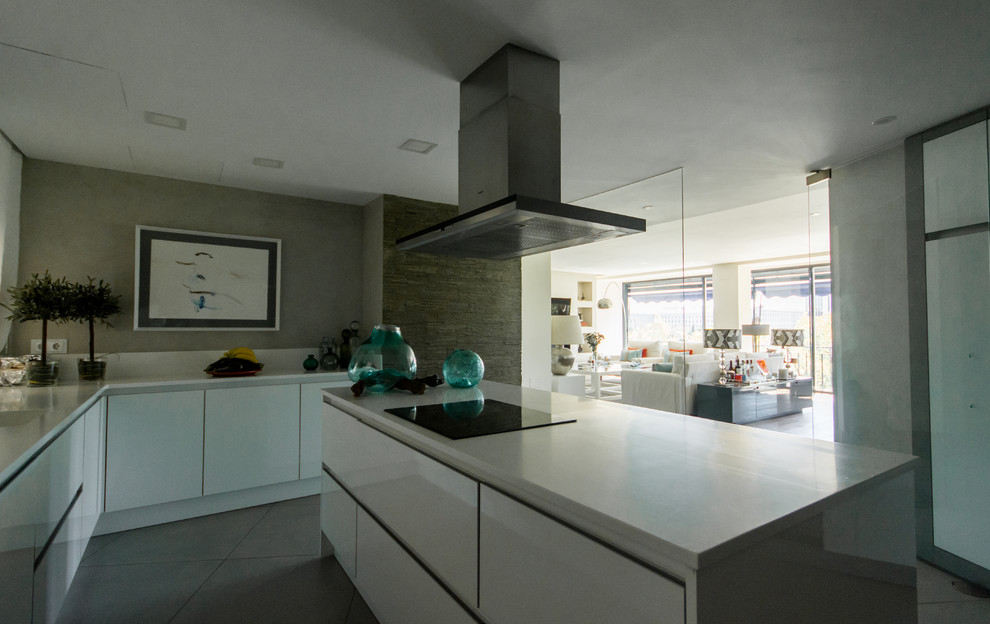 Modelo de cocina actual grande abierta con fregadero bajoencimera, armarios con paneles lisos, puertas de armario blancas, encimera de cuarzo compacto, salpicadero blanco, electrodomésticos de acero inoxidable, suelo de baldosas de porcelana, una isla y suelo gris