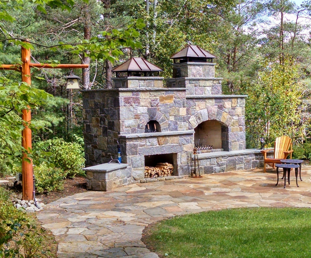 Inspiration for a large country backyard patio in New York with with fireplace, natural stone pavers and no cover.