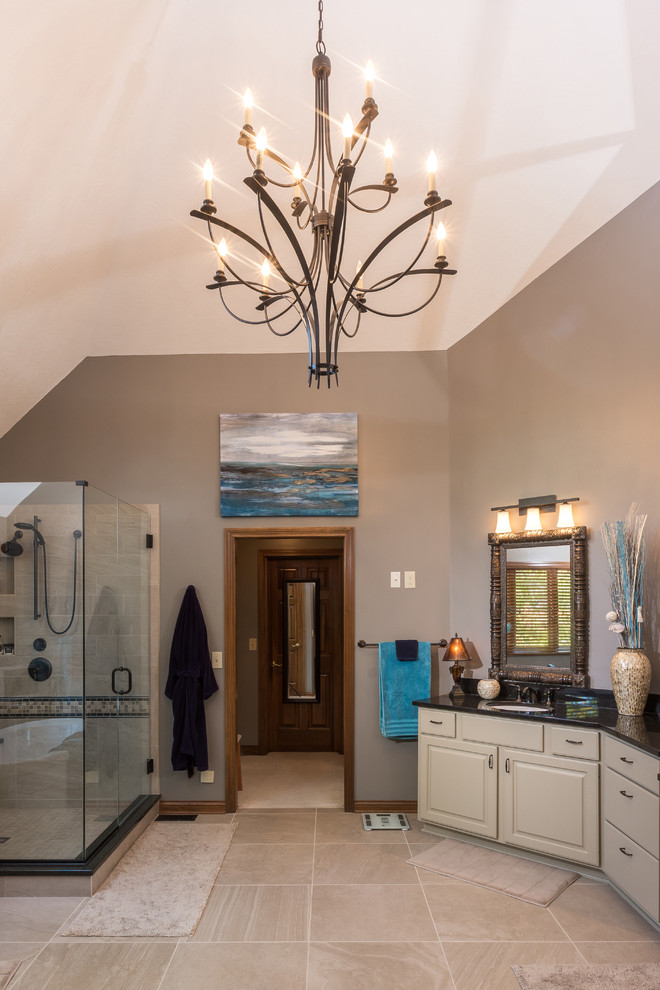 This is an example of a large transitional master bathroom in Columbus with raised-panel cabinets, beige cabinets, a freestanding tub, a double shower, a two-piece toilet, beige tile, porcelain tile, beige walls, porcelain floors, an undermount sink and granite benchtops.