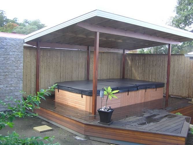 This is an example of a large traditional backyard rectangular aboveground pool in Other with a hot tub and decking.