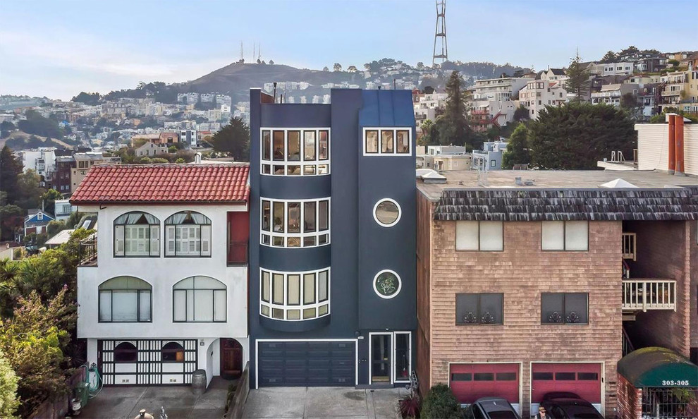 Inspiration for a large transitional three-storey stucco blue townhouse exterior in San Francisco with a flat roof and a metal roof.