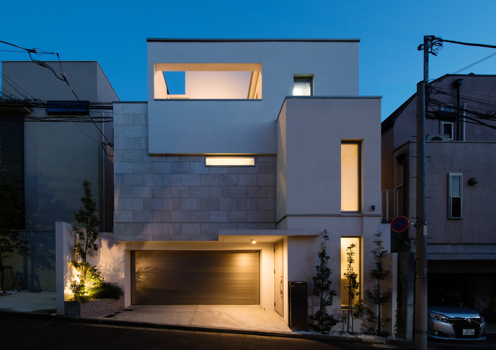 This is an example of a modern three-storey white house exterior in Tokyo with a flat roof.
