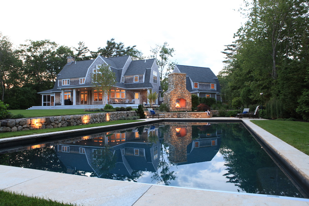 Inspiration for a large country backyard rectangular lap pool in Boston with concrete pavers.