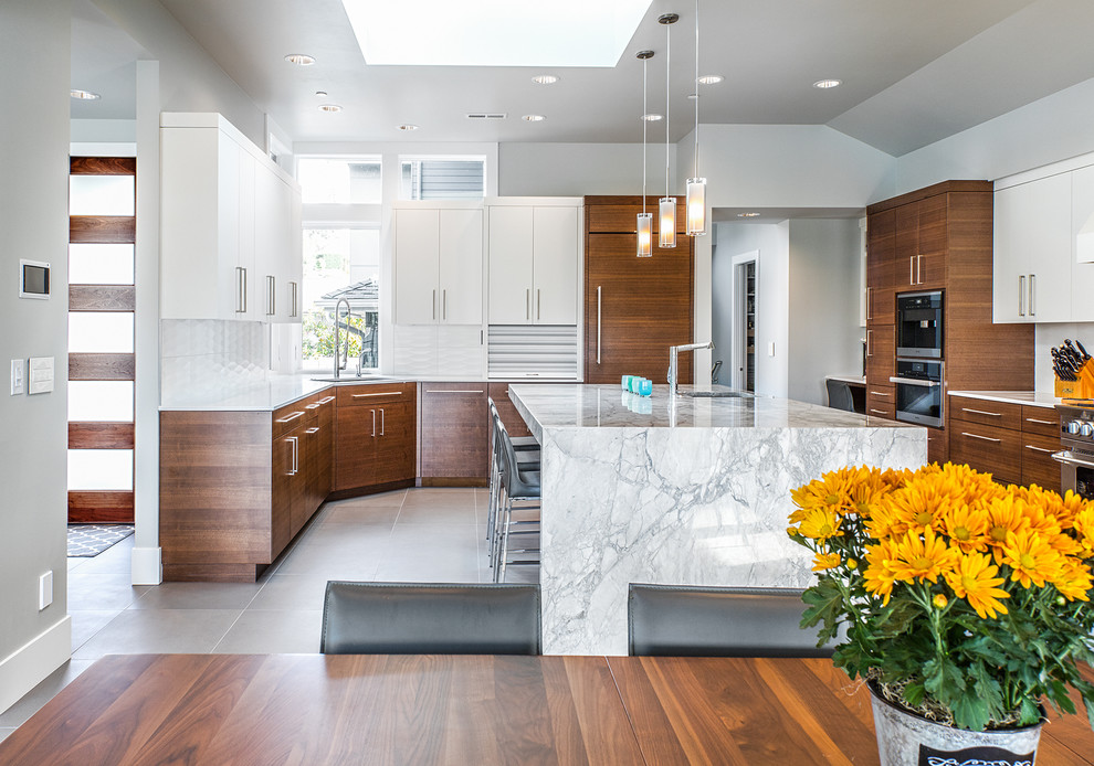 Photo of a large modern u-shaped open plan kitchen in Seattle with an undermount sink, flat-panel cabinets, dark wood cabinets, marble benchtops, white splashback, porcelain splashback, panelled appliances, ceramic floors, with island, grey floor and grey benchtop.