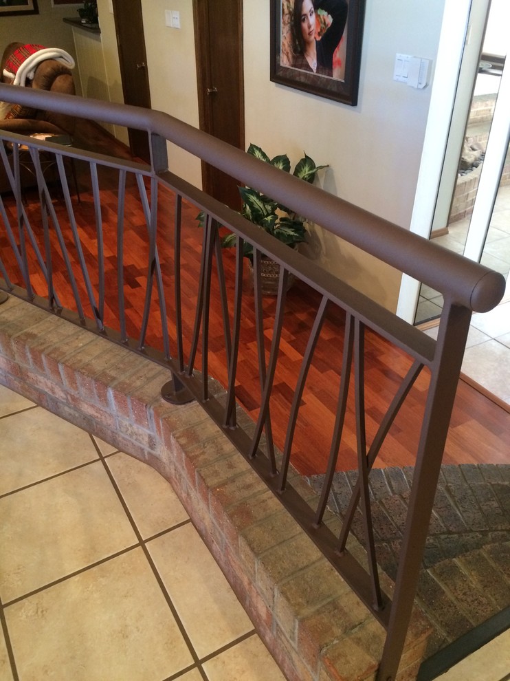 Ejemplo de escalera en L minimalista con escalones de metal, contrahuellas enmoquetadas y barandilla de metal