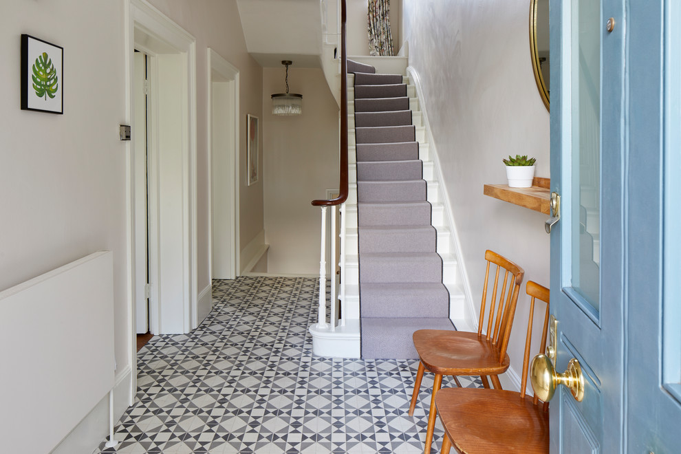 Mid-sized traditional entry hall in London with grey walls, a single front door, a blue front door and multi-coloured floor.