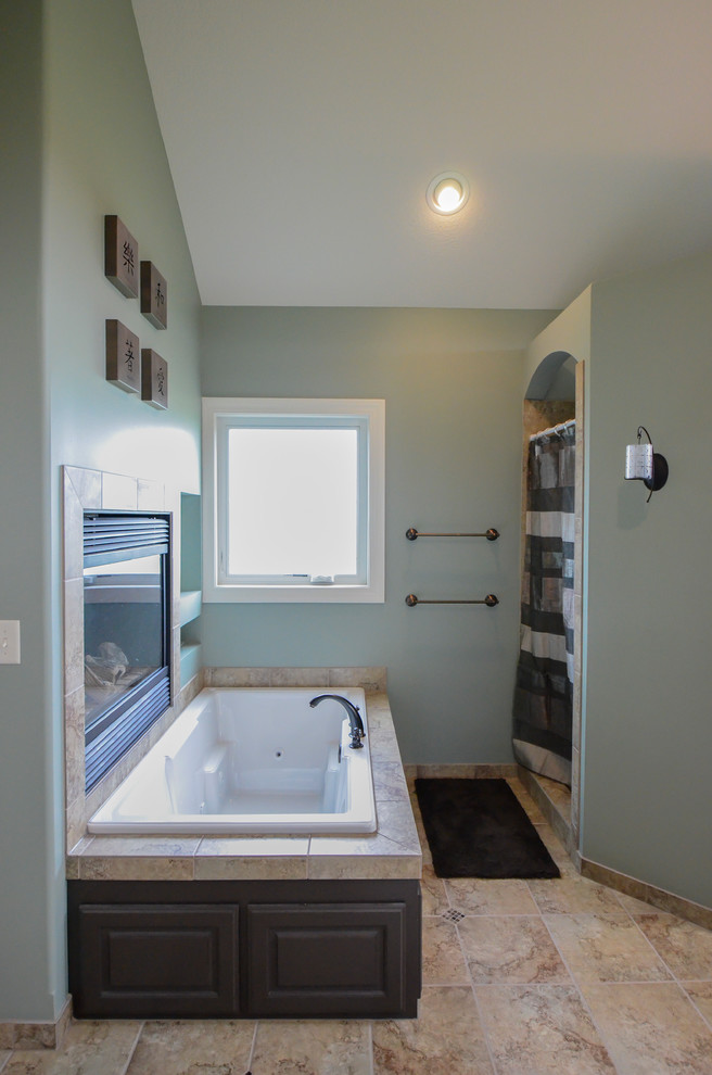 This is an example of a large arts and crafts master bathroom in Kansas City with raised-panel cabinets, grey cabinets, a corner tub, a corner shower, brown tile, ceramic tile, green walls and ceramic floors.