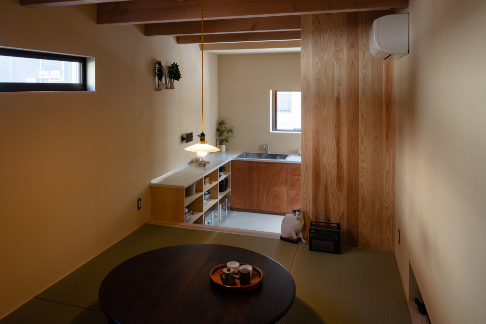 Foto di una piccola sala da pranzo aperta verso il soggiorno con pareti beige, pavimento in tatami, travi a vista e pareti in legno