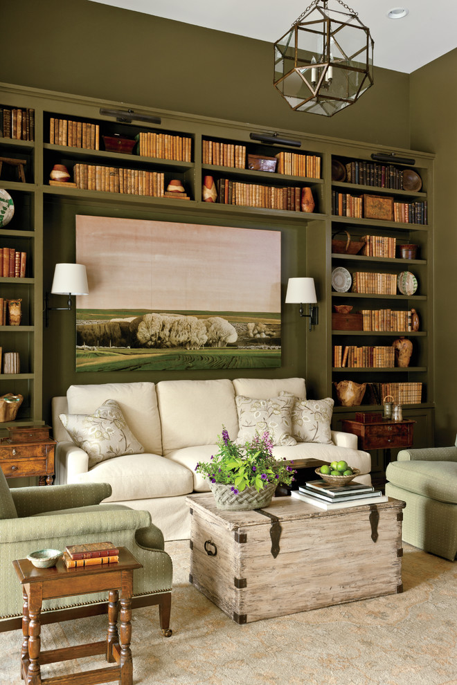 This is an example of a large country enclosed family room in Nashville with a library and green walls.