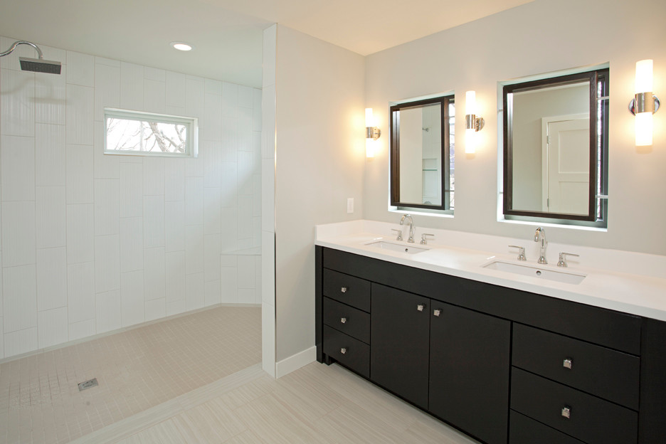Photo of a modern master bathroom in Minneapolis with an undermount sink, flat-panel cabinets, dark wood cabinets, solid surface benchtops, an open shower, white tile, porcelain tile, grey walls and ceramic floors.