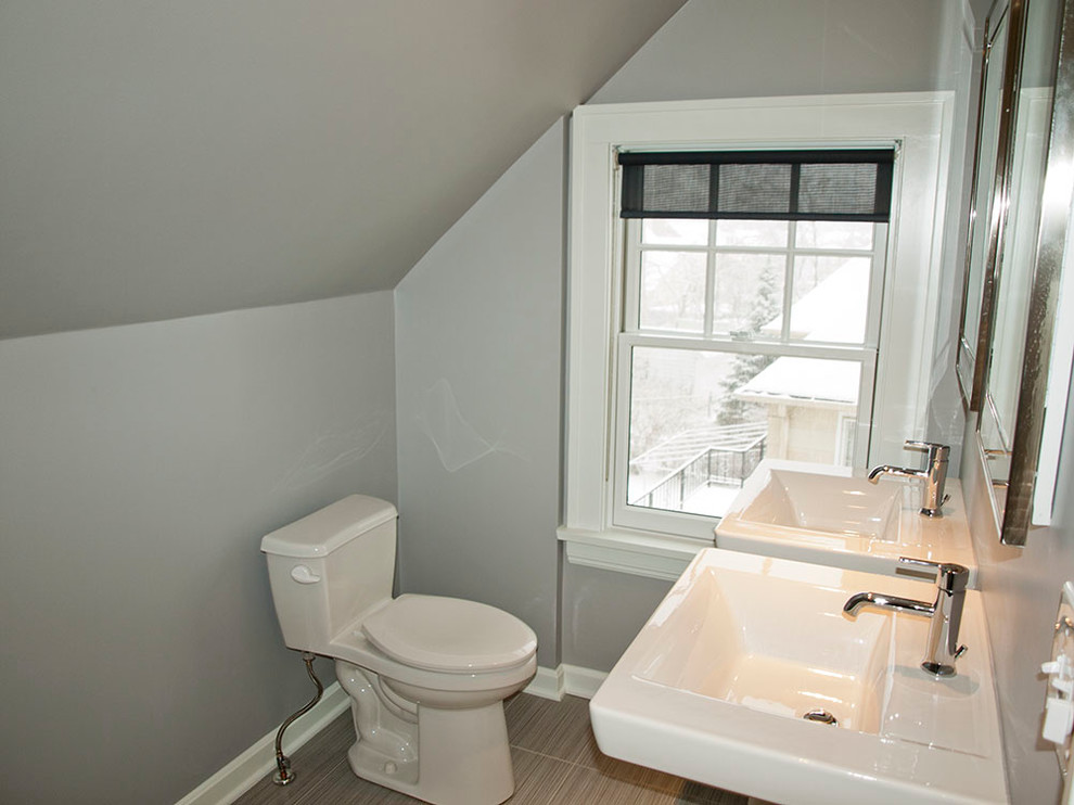 This is an example of a mid-sized contemporary master bathroom in Cleveland with a pedestal sink, a one-piece toilet, white tile, blue walls, porcelain floors and an alcove shower.