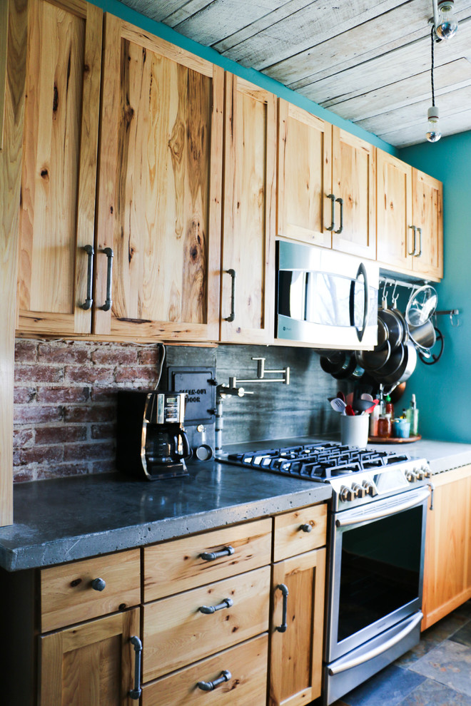 Kitchen - slate floor kitchen idea in Omaha with a farmhouse sink, light wood cabinets, concrete countertops, glass tile backsplash and stainless steel appliances