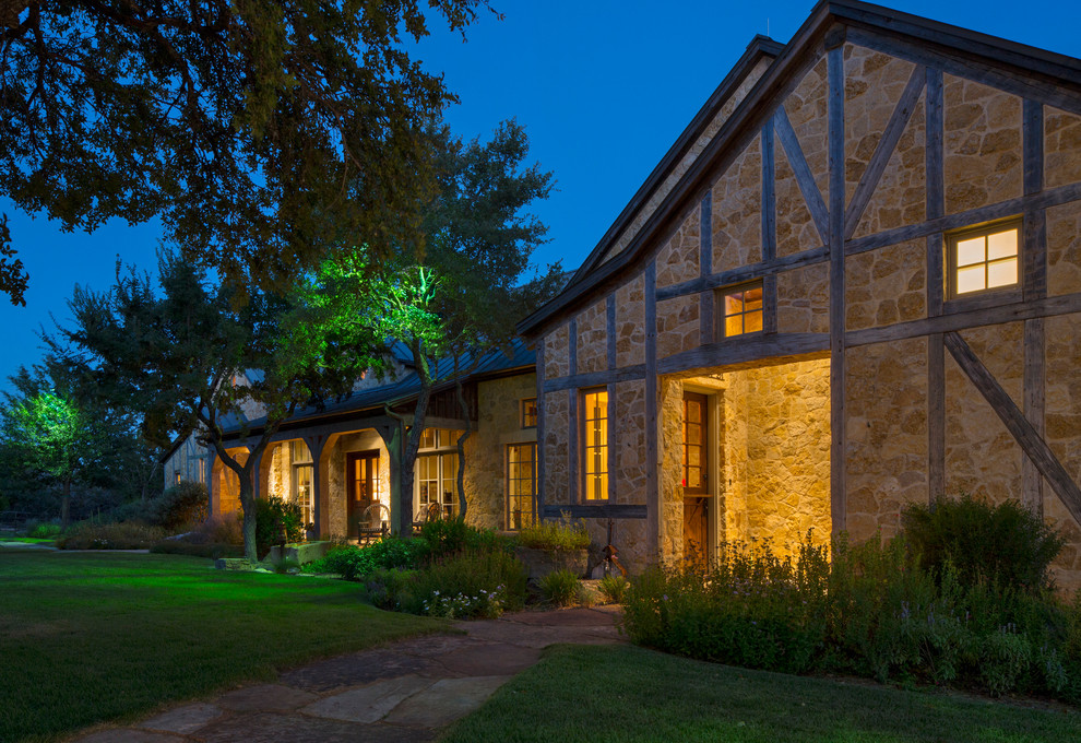Design ideas for a large country one-storey beige exterior in Austin with stone veneer.