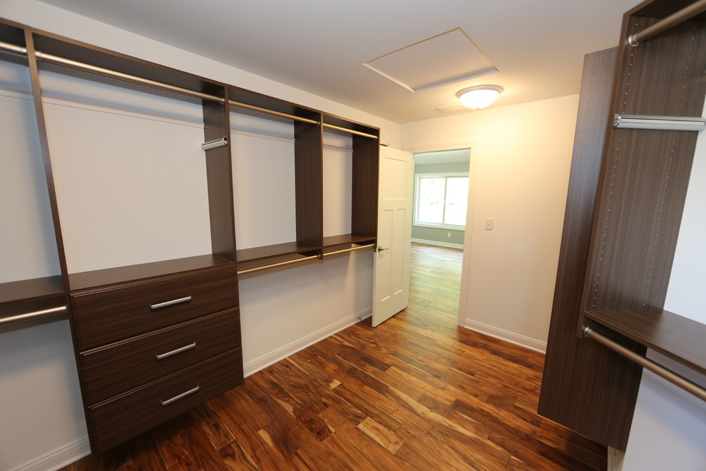Large traditional gender-neutral walk-in wardrobe in Chicago with medium hardwood floors, flat-panel cabinets and dark wood cabinets.