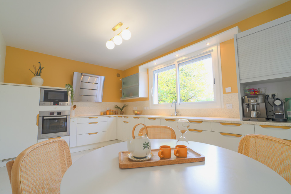 Источник вдохновения для домашнего уюта: большая угловая кухня в белых тонах с отделкой деревом в современном стиле с белыми фасадами, столешницей терраццо, разноцветным фартуком, разноцветной столешницей и мойкой у окна