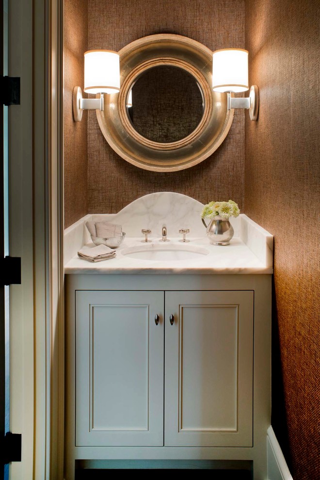 This is an example of a beach style powder room in Charleston with green cabinets, brown walls, a drop-in sink, marble benchtops and white benchtops.