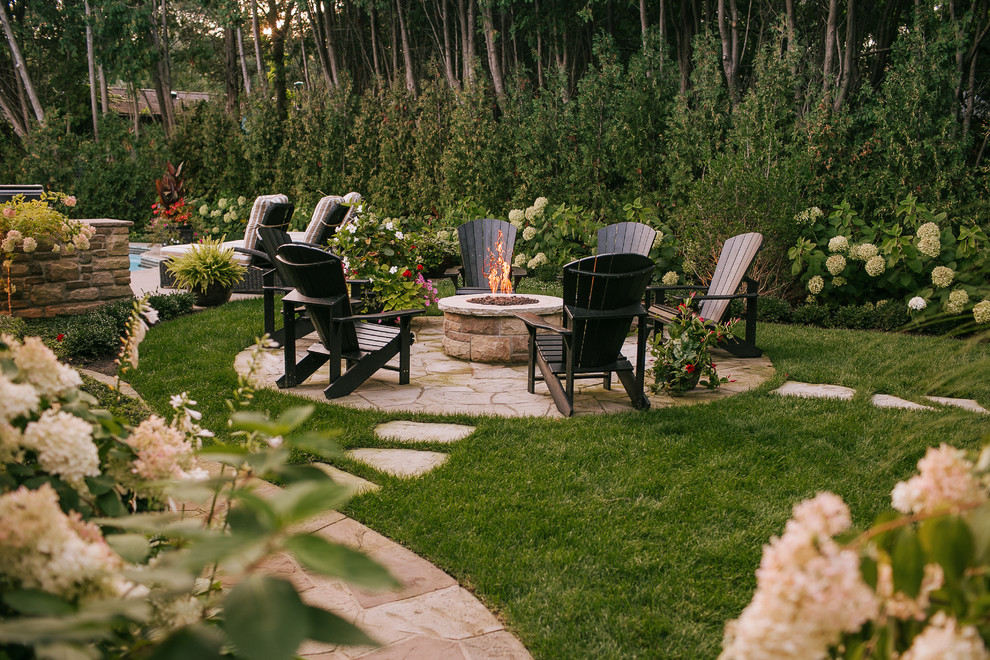 Inspiration for a mid-sized traditional backyard partial sun garden in Other with a fire feature and natural stone pavers.