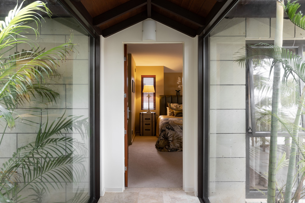 Großes Stilmix Hauptschlafzimmer ohne Kamin mit gelber Wandfarbe, Teppichboden, beigem Boden und Holzdielendecke in Auckland
