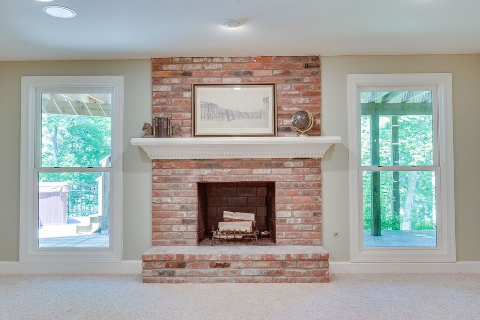 Design ideas for a large eclectic walk-out basement in Louisville with a brick fireplace surround.