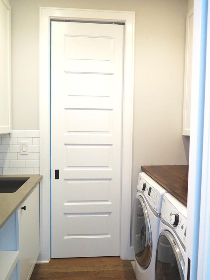 Design ideas for an expansive industrial galley utility room in DC Metro with an undermount sink, recessed-panel cabinets, grey cabinets, wood benchtops, grey walls, dark hardwood floors and a side-by-side washer and dryer.