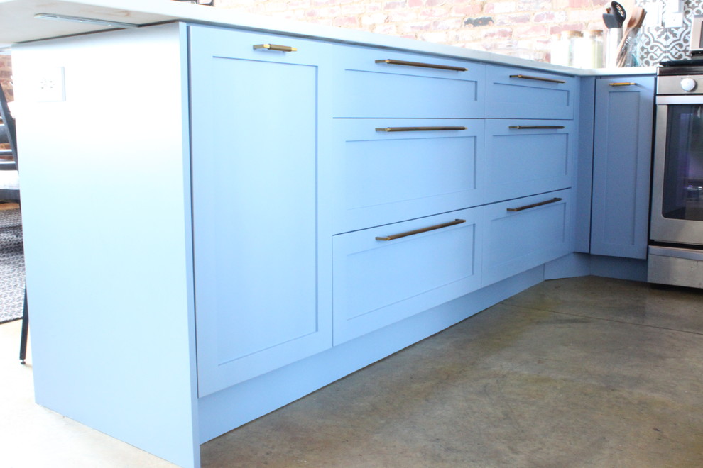 Inspiration for a mid-sized transitional u-shaped concrete floor and beige floor eat-in kitchen remodel in Atlanta with an undermount sink, glass-front cabinets, blue cabinets, quartzite countertops, multicolored backsplash, ceramic backsplash, stainless steel appliances, a peninsula and white countertops