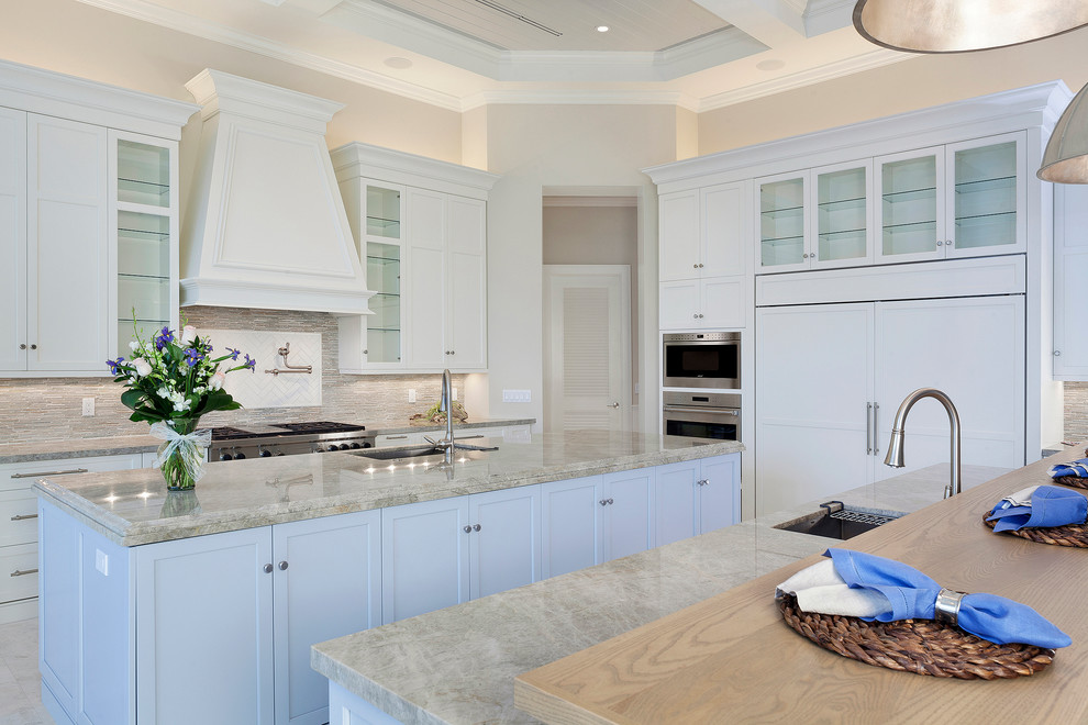 Open concept kitchen - large transitional u-shaped porcelain tile and beige floor open concept kitchen idea in Miami with an undermount sink, white cabinets, marble countertops, beige backsplash, stainless steel appliances, an island, recessed-panel cabinets, subway tile backsplash and multicolored countertops