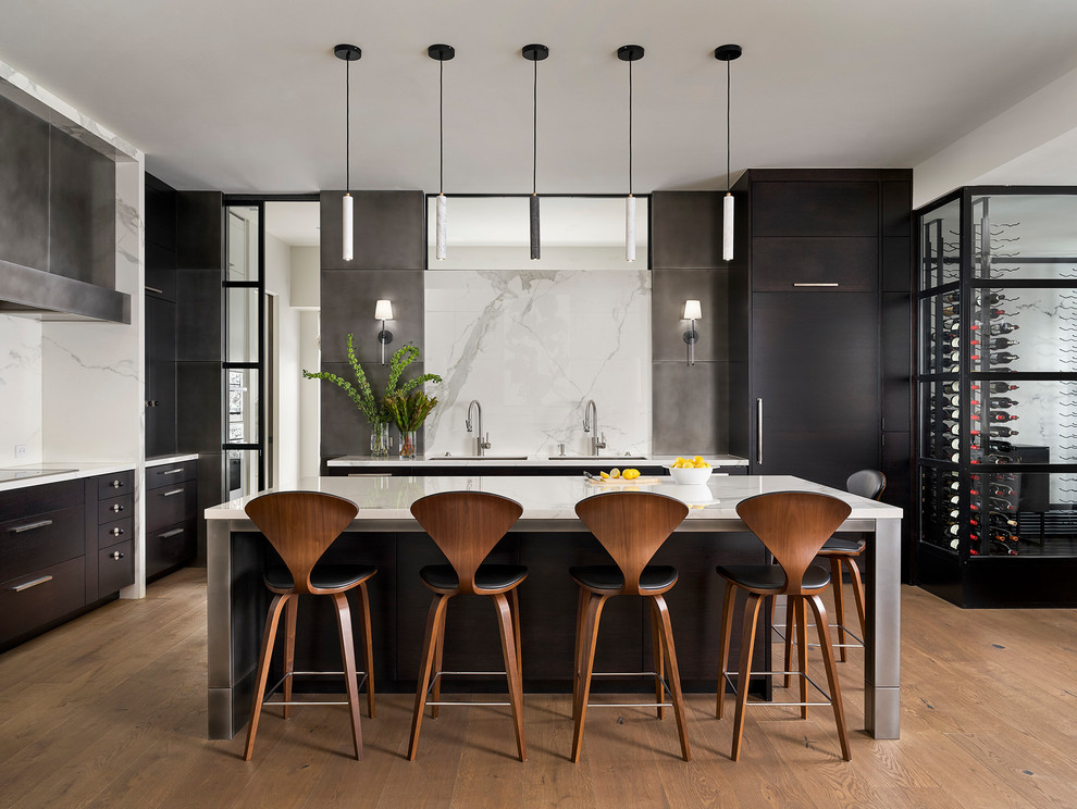 This is an example of a large contemporary kitchen in Denver with flat-panel cabinets, black cabinets, marble splashback, with island, white benchtop, an undermount sink, white splashback, panelled appliances and medium hardwood floors.