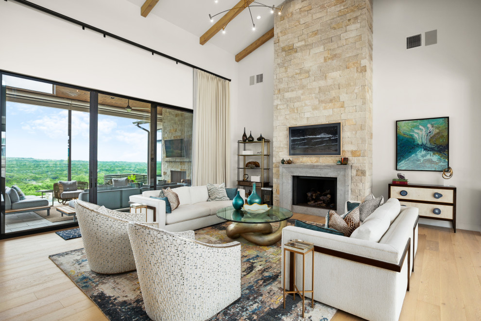 Design ideas for a large transitional formal enclosed living room in Austin with white walls, light hardwood floors, a standard fireplace, a stone fireplace surround, a wall-mounted tv and vaulted.