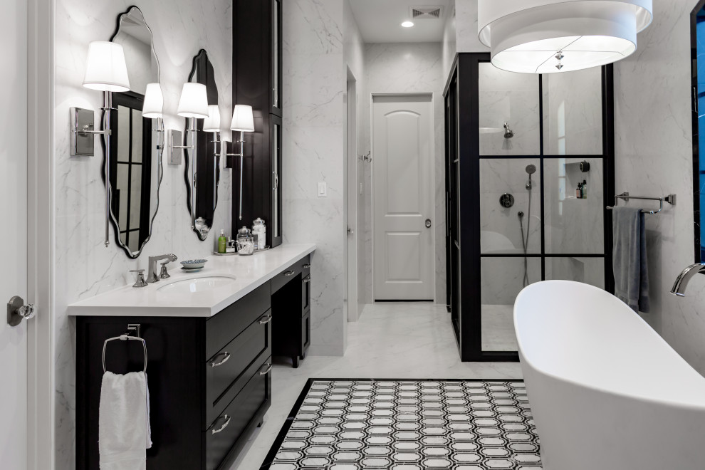 This is an example of a large transitional master bathroom in Houston with shaker cabinets, black cabinets, a freestanding tub, a corner shower, white tile, an undermount sink, multi-coloured floor, a hinged shower door and multi-coloured benchtops.
