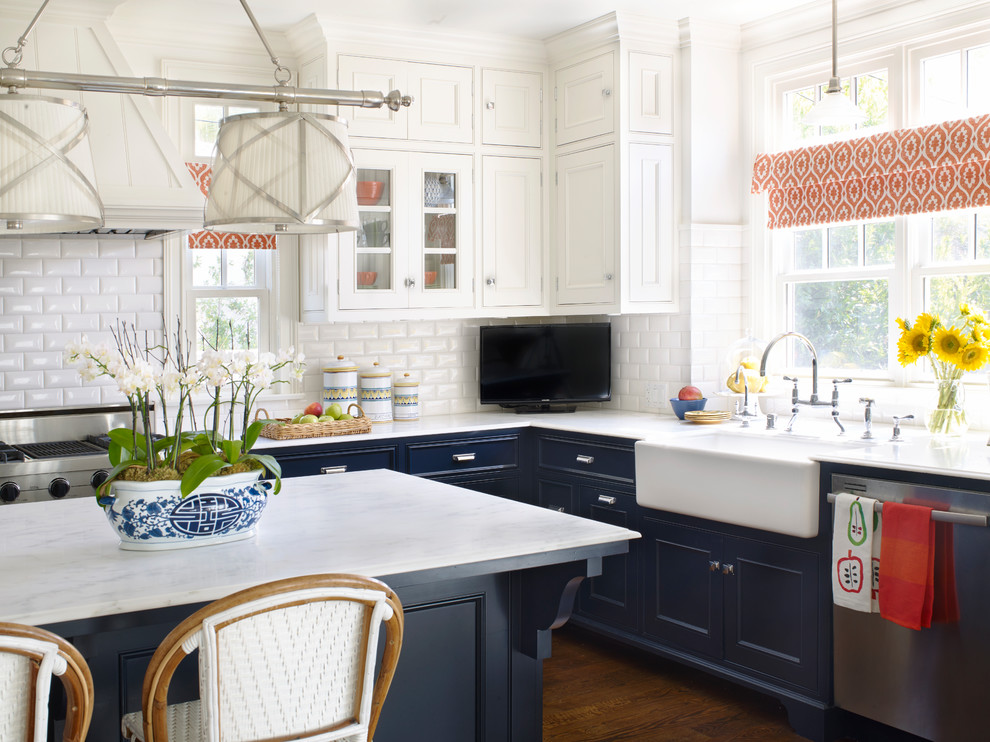 Design ideas for a large traditional eat-in kitchen in Los Angeles with a farmhouse sink, raised-panel cabinets, blue cabinets, marble benchtops, white splashback, ceramic splashback, stainless steel appliances and with island.