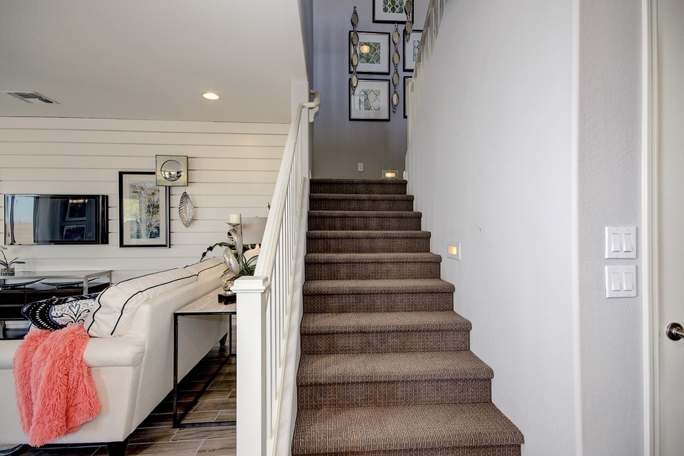 Small transitional carpeted straight staircase in Phoenix with carpet risers.