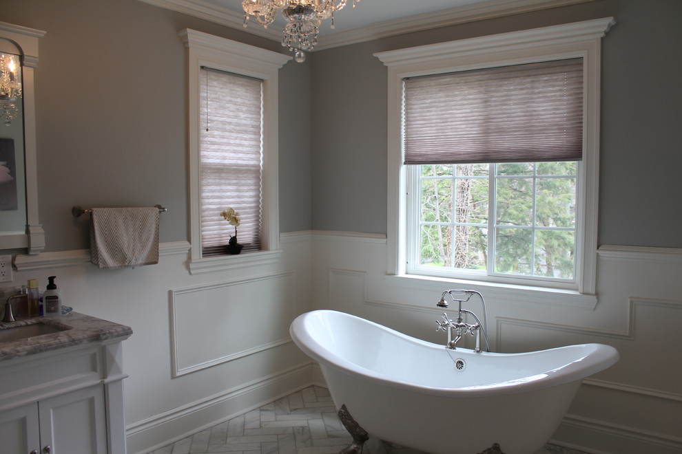 Large traditional master bathroom in Detroit with an undermount sink, recessed-panel cabinets, light wood cabinets, granite benchtops, a freestanding tub, an open shower, a one-piece toilet, white tile, stone tile, white walls and marble floors.