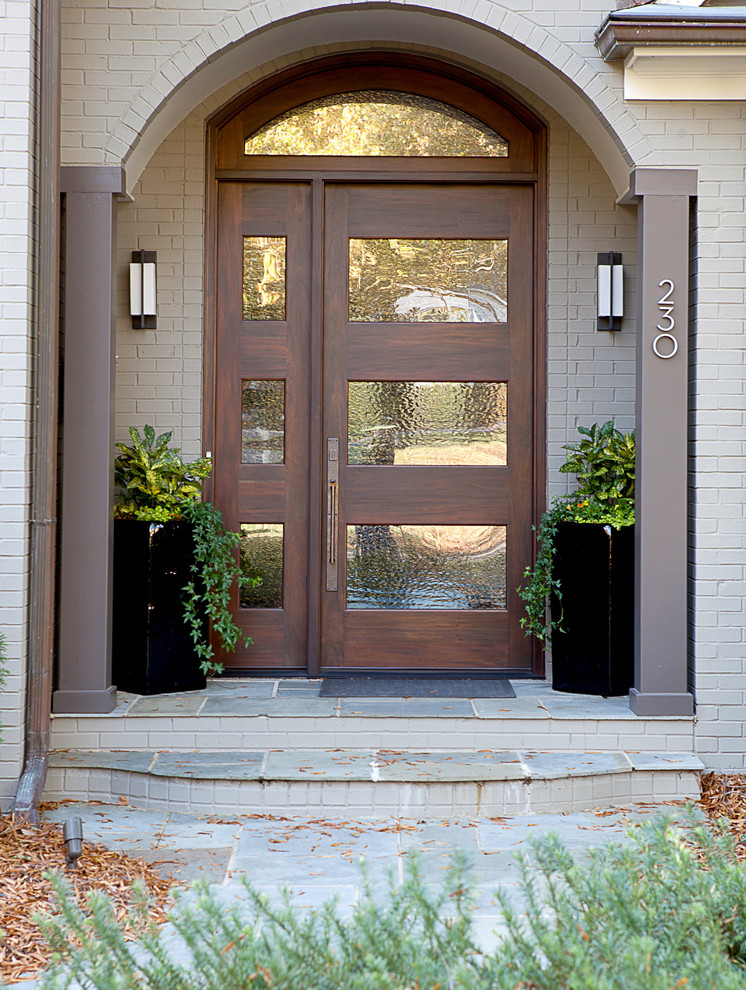 Photo of a transitional entryway in Other with beige walls, slate floors, a single front door and a medium wood front door.
