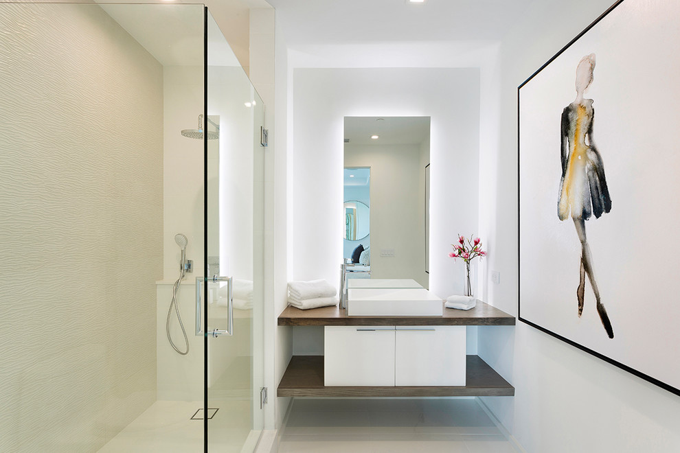 This is an example of a mid-sized modern master bathroom in Miami with flat-panel cabinets, white cabinets, a one-piece toilet, white tile, porcelain tile, white walls, linoleum floors, engineered quartz benchtops, beige floor, a hinged shower door, white benchtops, a corner shower and a drop-in sink.