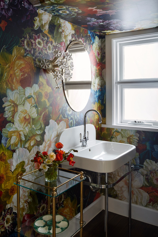 Inspiration for a transitional powder room in Melbourne with multi-coloured walls, a console sink, black floor and wallpaper.
