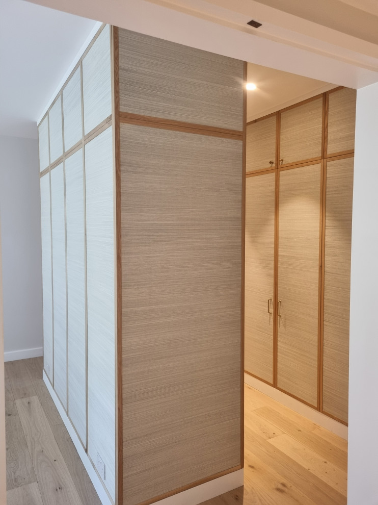Idee per una grande camera matrimoniale minimalista con pareti beige e pavimento in compensato