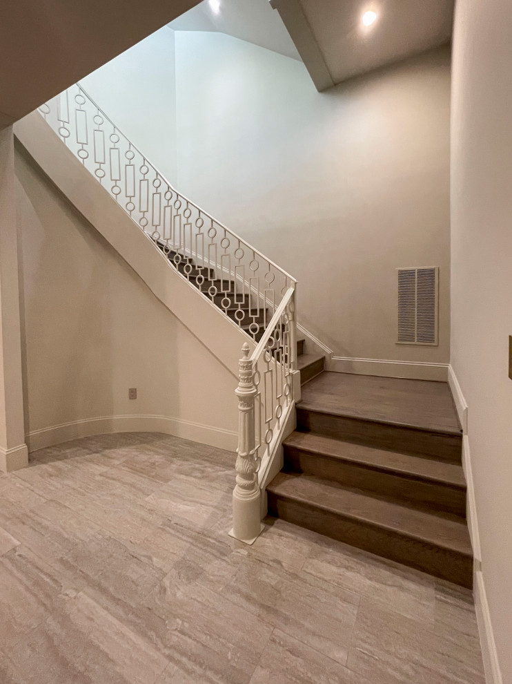 Expansive transitional wood floating staircase in DC Metro with wood risers, metal railing and panelled walls.