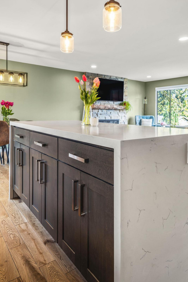 Photo of a large midcentury l-shaped kitchen in Seattle with shaker cabinets, dark wood cabinets, marble benchtops, mosaic tile splashback, stainless steel appliances and with island.