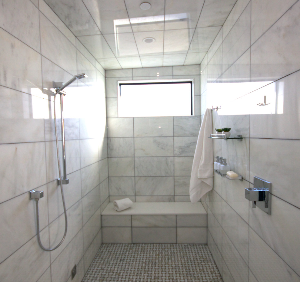 На фото: большая главная ванная комната в стиле модернизм с плоскими фасадами, темными деревянными фасадами, отдельно стоящей ванной, душевой комнатой, унитазом-моноблоком, белой плиткой, каменной плиткой, белыми стенами, мраморным полом, врезной раковиной, столешницей из искусственного камня, белым полом, душем с распашными дверями, белой столешницей, сиденьем для душа, тумбой под две раковины и напольной тумбой с
