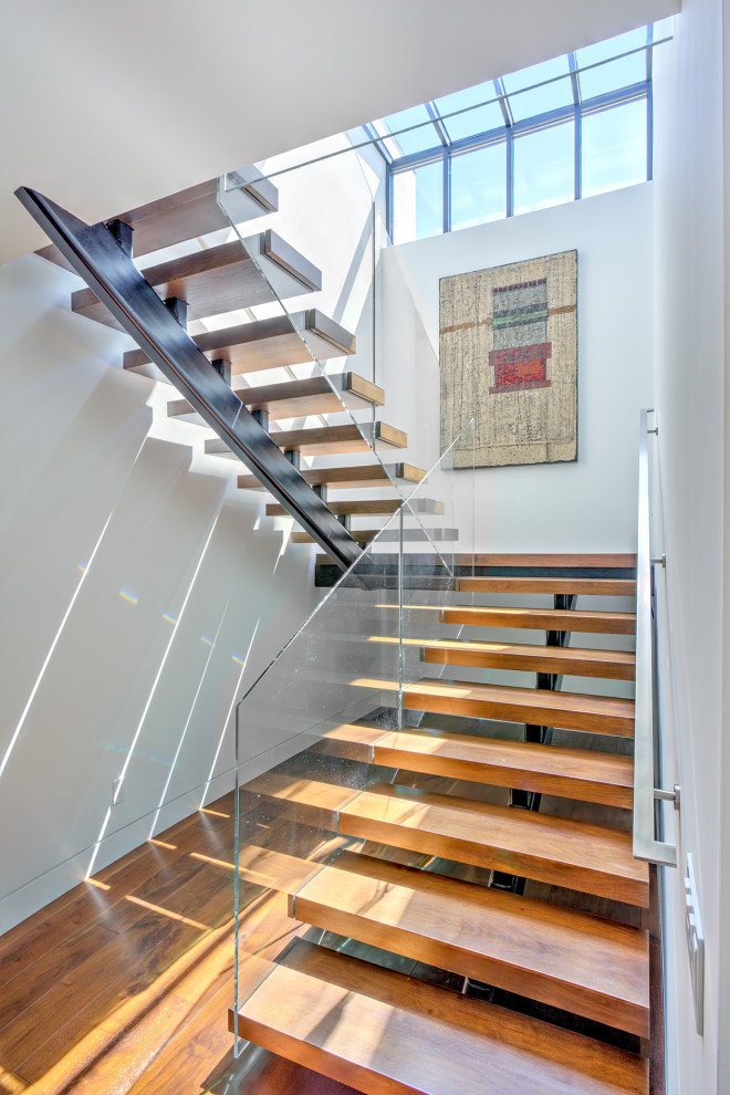 Mid-sized beach style wood floating staircase in Orange County with open risers and metal railing.