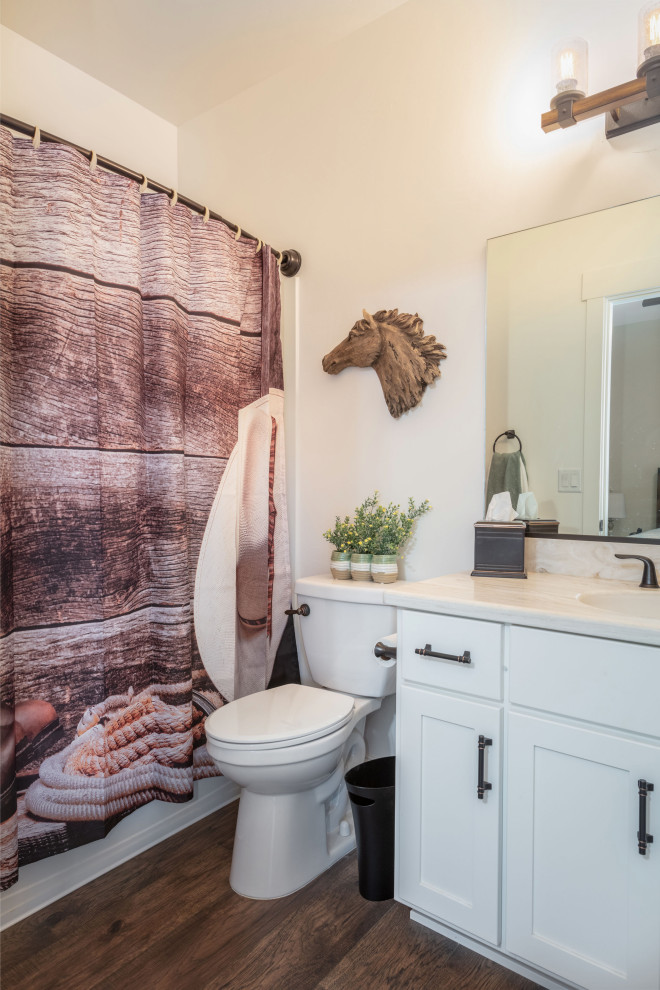Inspiration for a mid-sized country kids bathroom in Sacramento with shaker cabinets, white cabinets, a shower/bathtub combo, a two-piece toilet, beige walls, dark hardwood floors, an integrated sink, quartzite benchtops, white floor, a shower curtain, white benchtops, a single vanity and a built-in vanity.