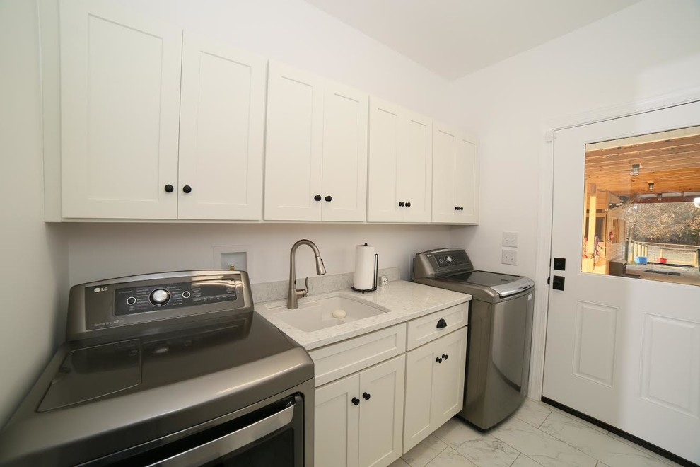 Photo of a mid-sized traditional single-wall laundry room in Atlanta with an undermount sink, shaker cabinets, white cabinets, marble benchtops, white walls, marble floors and a side-by-side washer and dryer.