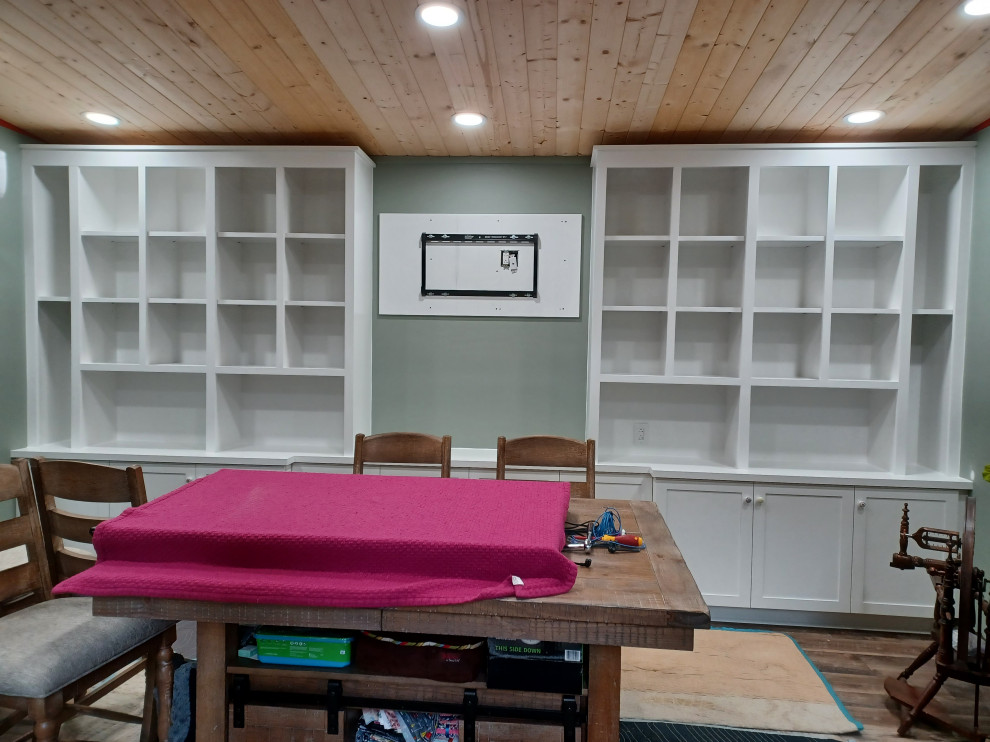 Exemple d'un grand bureau atelier tendance avec un mur vert, un sol en bois brun, un bureau intégré, un sol marron et un plafond en bois.