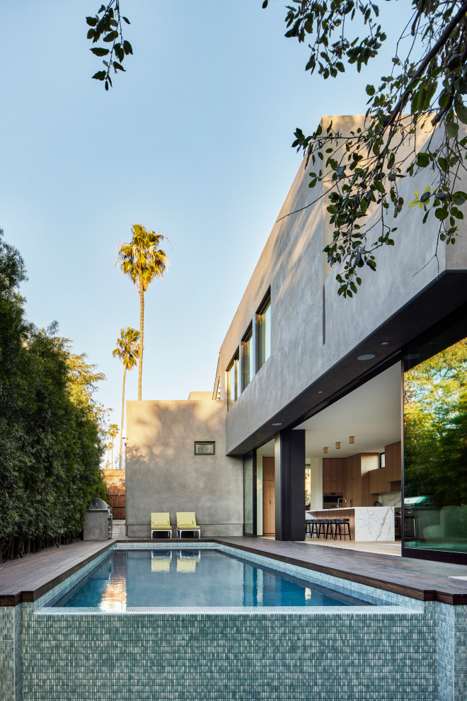 This is an example of an expansive modern split-level stucco grey house exterior in Los Angeles with a flat roof.