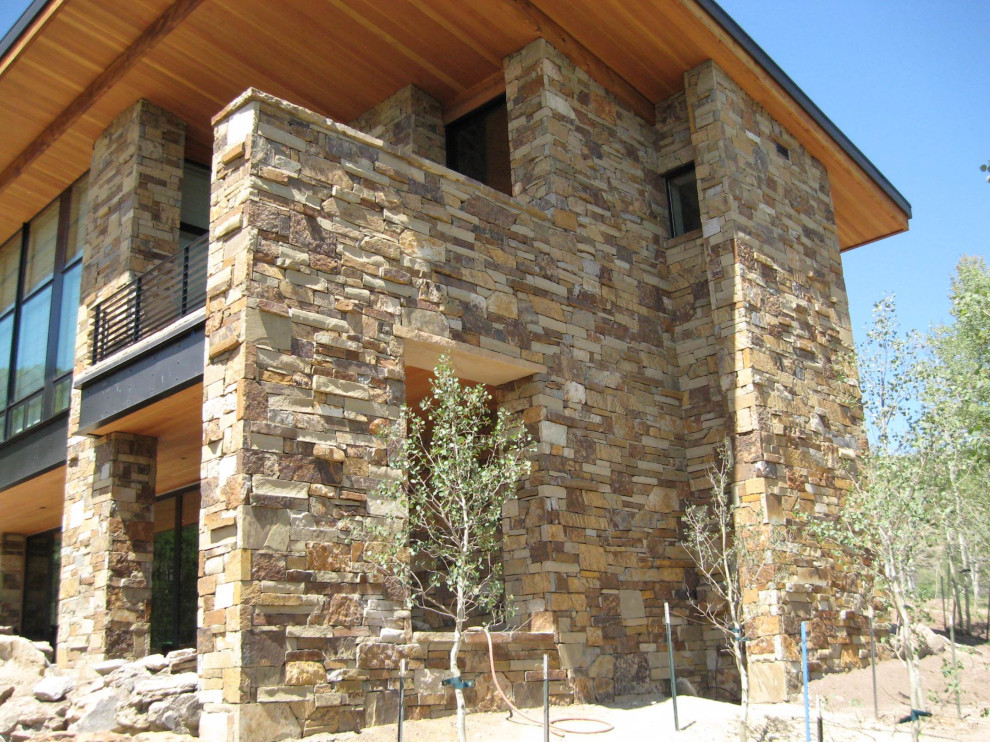 Inspiration for a large contemporary one-storey beige house exterior in Boise with stone veneer, a shingle roof and a grey roof.
