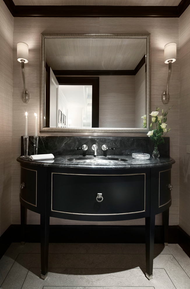 Inspiration for a large traditional powder room in Chicago with an undermount sink, furniture-like cabinets, black cabinets, beige walls, black tile, slate, limestone floors, granite benchtops, grey floor, black benchtops, a freestanding vanity, recessed and wallpaper.